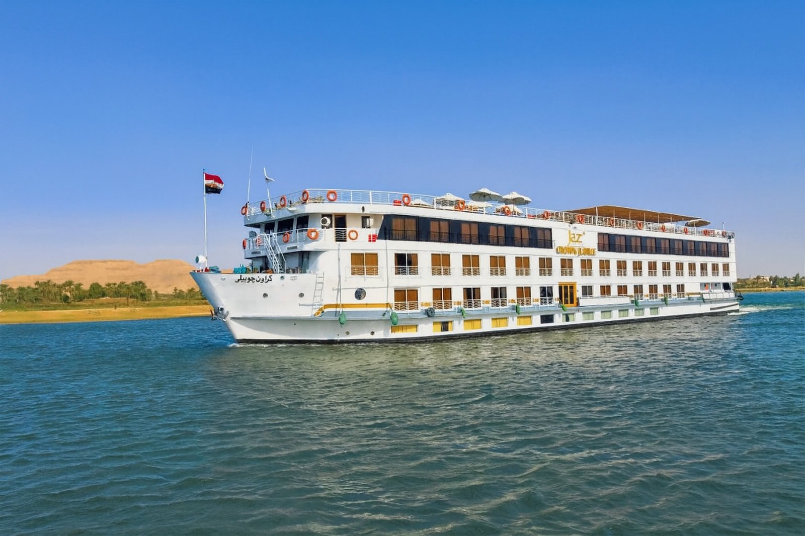 Crucero por el r&iacute;o Nilo con bandera egipcia navegando por aguas serenas